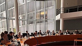  Die Teilnehmenden der Sitzung in einem Raum des Deutschen Bundestages.