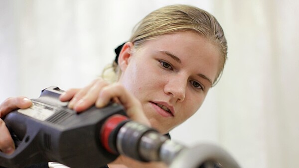 Junge Frau mit Bohrmaschine