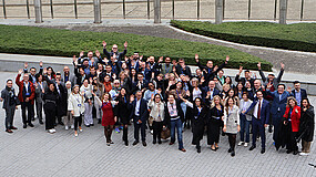 Gruppenfoto mit Teilnehmenden des EU-Policy-Camps 2024. Die Personen stehen in einer Gruppe zusammen, im Hintergrund ist ein Rasen und ein Gebäude zu sehen.