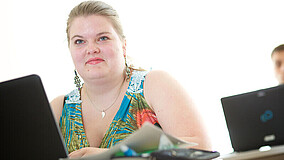 Junge Frau arbeitet am Laptop