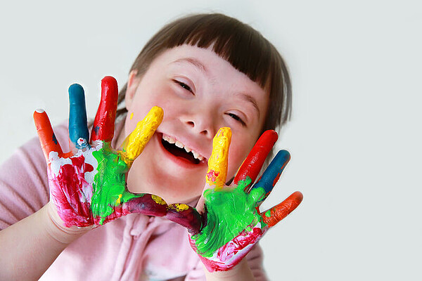 Mädchen mit Behinderung beim Spielen mit Fingerfarben