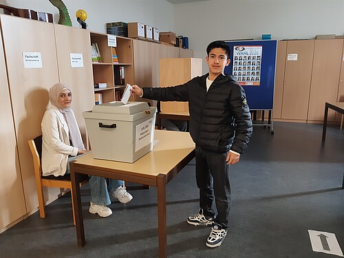 Junge steht an Wahlurne
