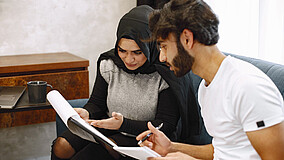 Eine Frau und ein Mann schauen sich ein Dokument an.