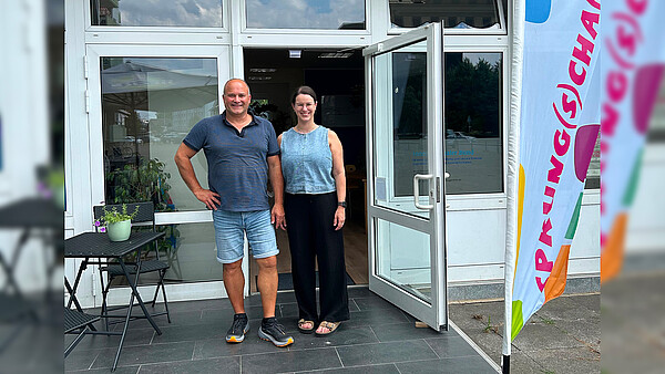 Elmar Prinz und Anne Nyssen von der Beratungsstelle Sprung(s)chance des Internationalen Bundes in Dormagen stehen lächelnd vor dem Gebäude der Einrichtung.