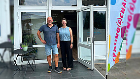 Elmar Prinz und Anne Nyssen von der Beratungsstelle Sprung(s)chance des Internationalen Bundes in Dormagen stehen lächelnd vor dem Gebäude der Einrichtung.