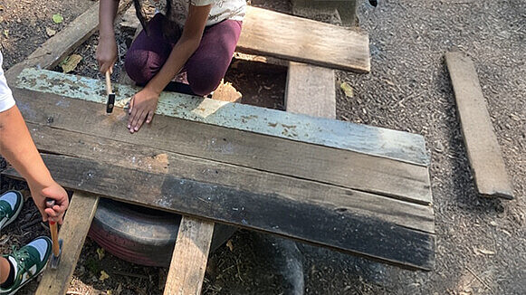 Zwei Menschen arbeiten mit Holz.