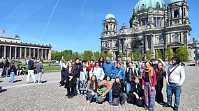 Gruppenporträt der Teilnehmenden des IB-Jugendaustauschs aus Deutschland und Frankreich auf einem Platz in Berlin, im Hintergrund ein historisches Gebäude.