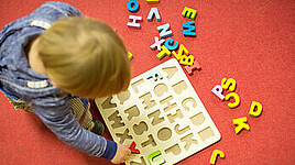 Kleinkind spielt mit Buchstaben