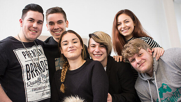 Eine Gruppe Jugendlicher lächelt in die Kamera.