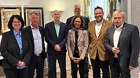 Gruppe von Menschen lächelt in die Kamera.