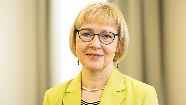 Portraitaufnahme von Karola Becker, Vorstandsmitglied beim Internationalen Bund (IB). Sie lächelt in die Kamera.