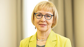 Portraitaufnahme von Karola Becker, Vorstandsmitglied beim Internationalen Bund (IB). Sie lächelt in die Kamera.