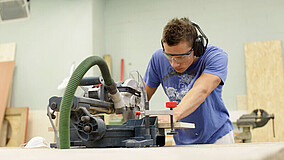 Auszubildender in holzverarbeitendem Betrieb