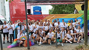 Menschen mit bunten Fächern sitzen vor einem bunt geschmückten Truck..