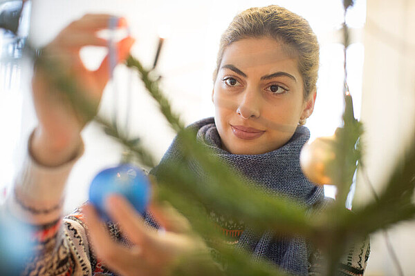 Jugendliche beim Schmücken des Weihnachtsbaums in einer IB-Einrichtung