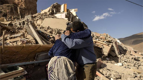Erdbebenopfer vor zerstörtem Haus in Marokko